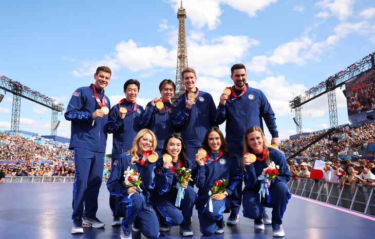 Các thành viên đội trượt băng nghệ thuật Mỹ nhận tấm HCV Olympic mùa đông 2022 ngay dưới chân tháp Eiffel kỳ Olympic 2024 này - Ảnh: GETTY