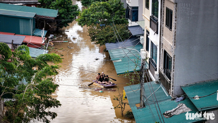 Người làng gốm Bát Tràng dùng thuyền đi lại trong nước lũ