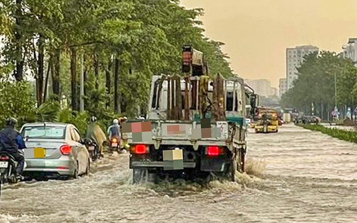 Xe lớn đánh sóng làm ướt sũng người đi đường trong cơn ngập - Ảnh 2.