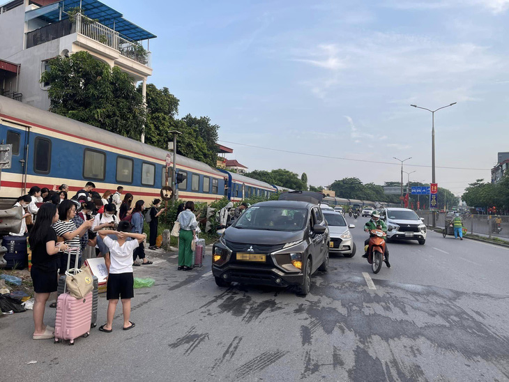 Ô tô biến dạng sau va chạm với tàu hỏa ở Hà Nội, nhiều hành khách lỉnh kỉnh đồ đạc bước xuống tàu - Ảnh 2.