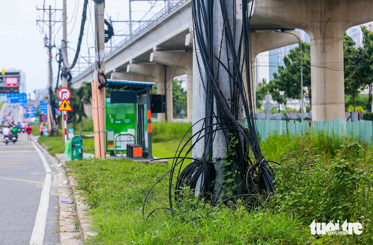 Cáp viễn thông lòng thòng treo ‘nhờ’ cột điện lực: Cả hai phải bàn nhau thu gọn - Ảnh 1.