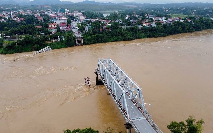 Nước lũ kéo đổ trụ T7 làm sập 2 nhịp chính cầu Phong Châu - Ảnh 1.