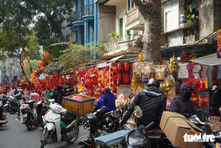 Phố Hàng Mã ngập sắc đỏ hút khách nhờ mẫu trang trí Tết từ giỏ bắt cá, cái đơm, cái đó - Ảnh 1.