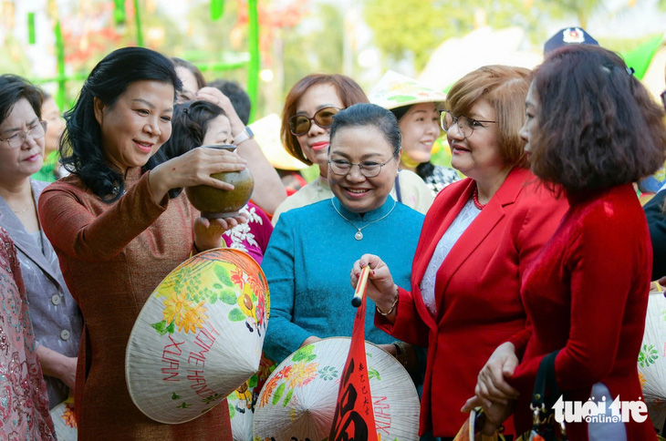 Phu nhân Ngô Phương Ly trổ tài 'vào bếp', gói bánh chưng cùng các nữ đại sứ - Ảnh 6.