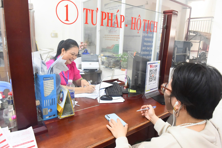 Người dân phường sắp xếp ở TP.HCM đi đổi giấy tờ không sợ tốn tiền - Ảnh 1.