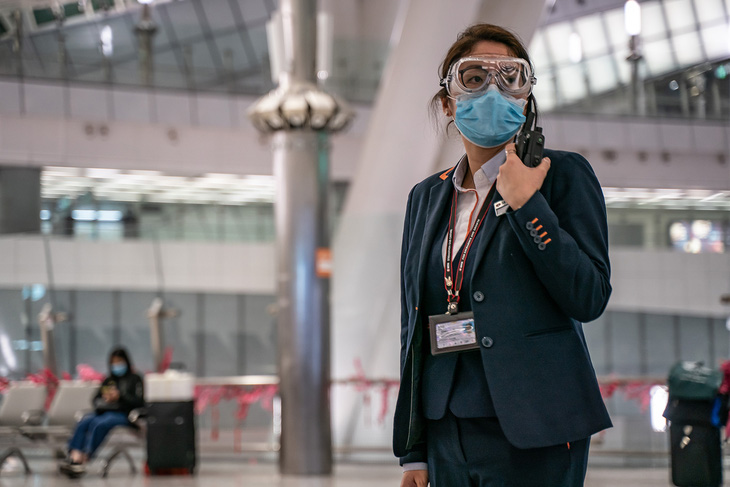Một nhân viên đeo kính bảo hộ và mặt nạ, đứng trong sảnh khởi hành tại ga đường sắt cao tốc Hồng Kông vào ngày 29 tháng 1 năm 2020. Hình của Anthony Kwan (Getty Images).