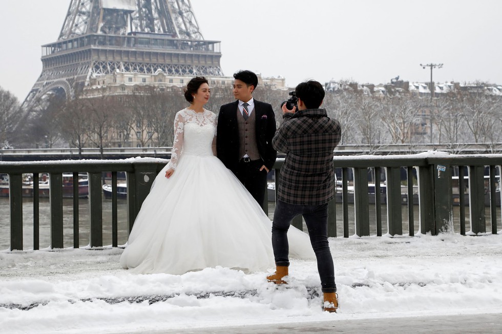 Chụp ảnh cưới nơi tháp Eiffel khoác màu tuyết trắng - Ảnh 1. Chụp ảnh cưới nơi tháp Eiffel khoác màu tuyết trắng - Ảnh 1.