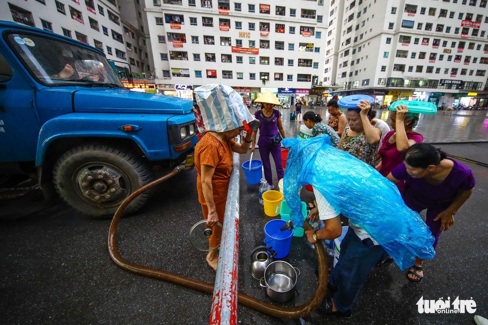 Người dân Hà Nội đội mưa hứng nước sạch - Ảnh 2. Người dân Hà Nội đội mưa hứng nước sạch - Ảnh 2.