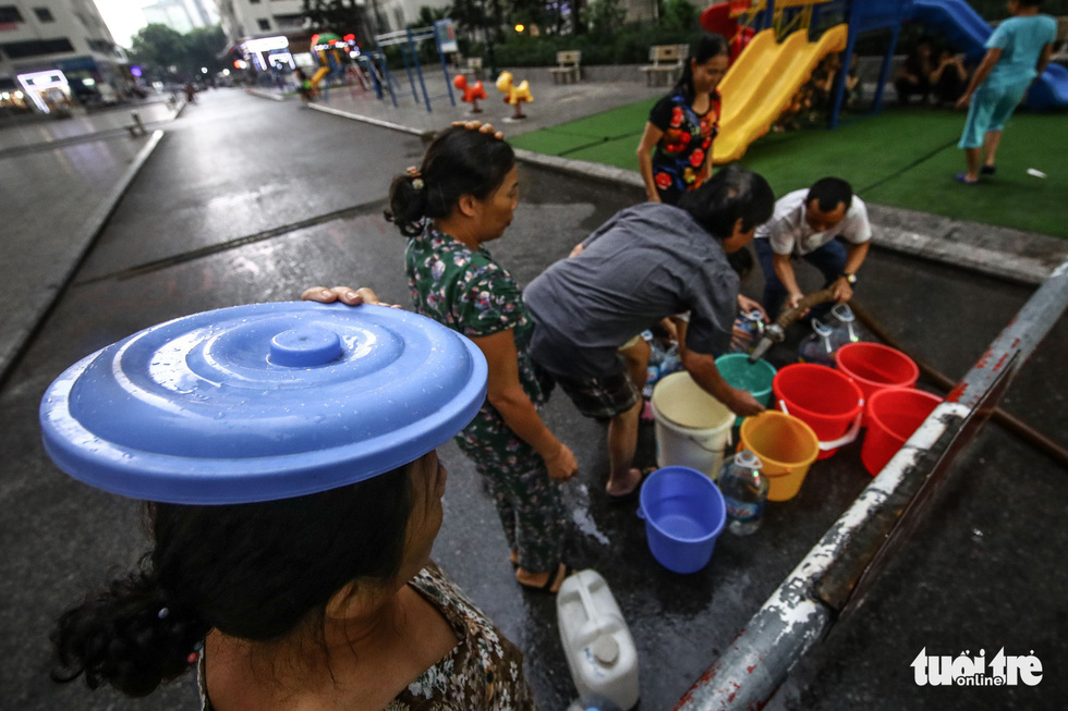 Người dân Hà Nội đội mưa hứng nước sạch - Ảnh 3. Người dân Hà Nội đội mưa hứng nước sạch - Ảnh 3.