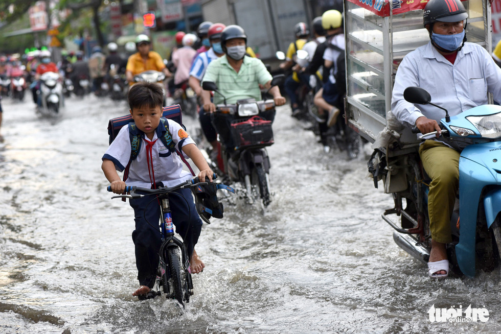 Triều cường dâng cao, học sinh, công nhân ở TP.HCM lội nước về nhà - Ảnh 3.