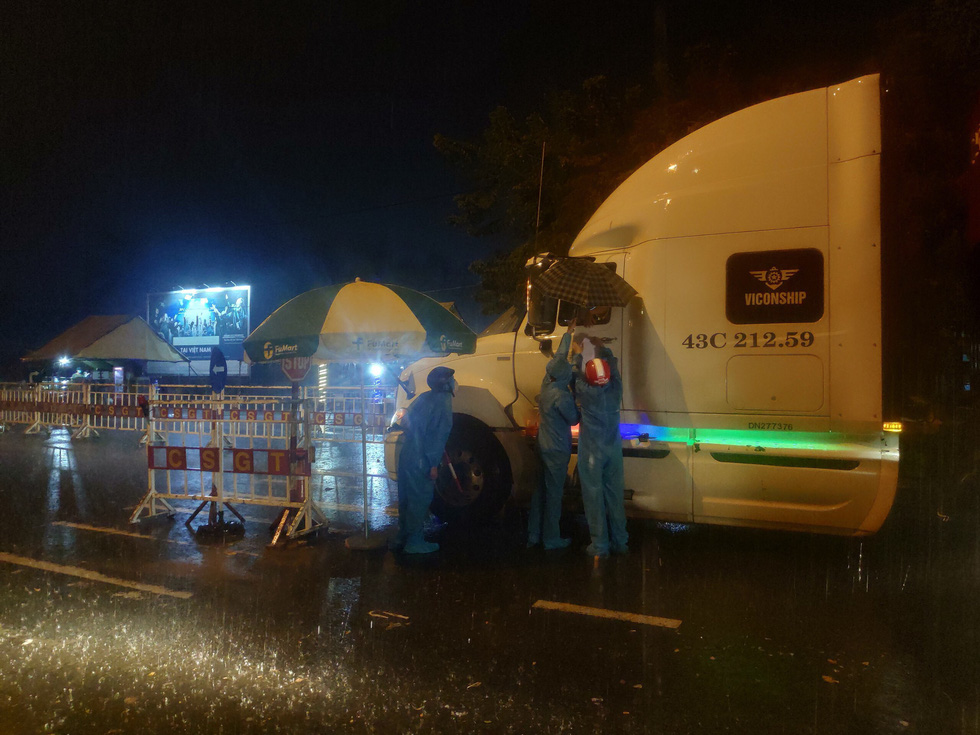 Hình ảnh tình nguyện viên đội mưa, bám cabin kiểm soát xe trong đêm gây xúc động - Ảnh 3.