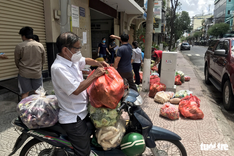 Cán bộ phường cùng bộ đội xắn tay lặt rau, đóng gói thực phẩm mang cho dân - Ảnh 3.
