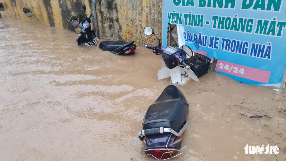 Mưa lớn kéo dài tại Quy Nhơn, xe máy và người đi đường bị nước cuốn - Ảnh 6.