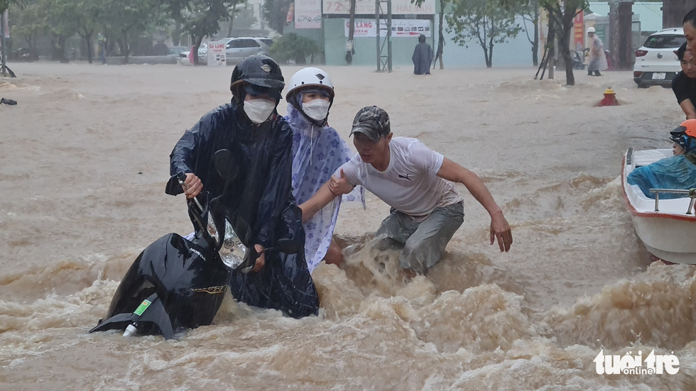 Mưa lớn kéo dài tại Quy Nhơn, xe máy và người đi đường bị nước cuốn - Ảnh 3.