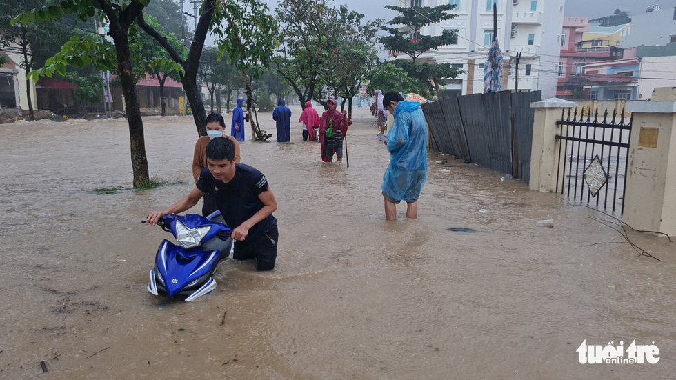 Mưa lớn kéo dài tại Quy Nhơn, xe máy và người đi đường bị nước cuốn - Ảnh 5.