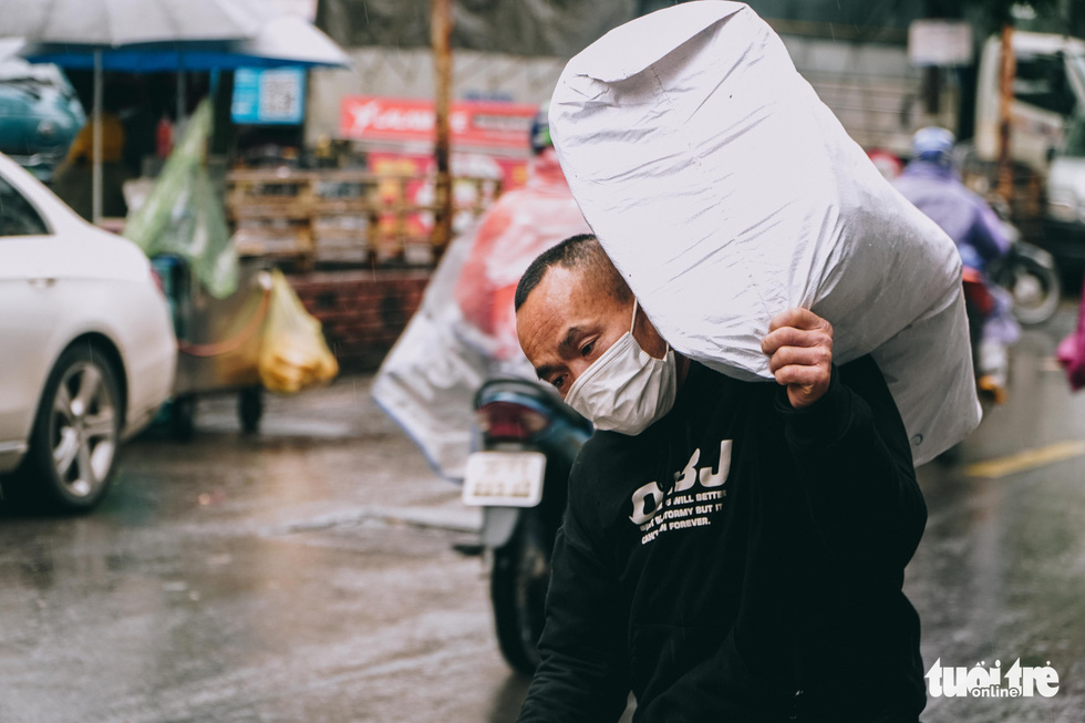 Người lao động ở Hà Nội trùm áo mưa, đốt lửa chống rét để mưu sinh - Ảnh 9.