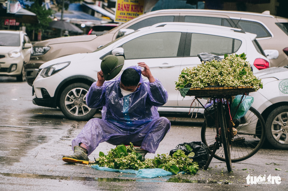Người lao động ở Hà Nội trùm áo mưa, đốt lửa chống rét để mưu sinh - Ảnh 1.