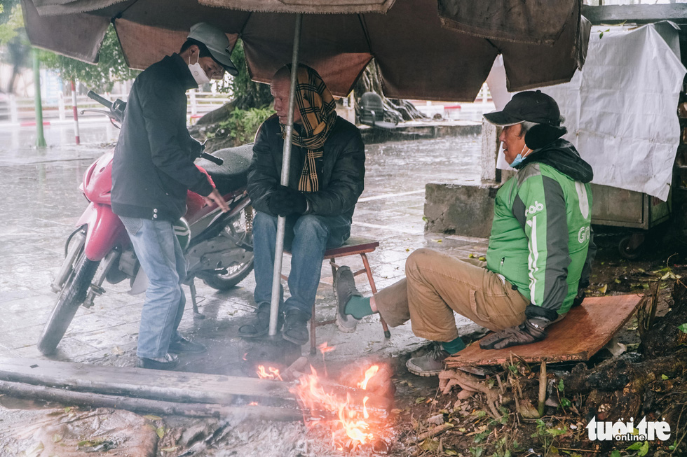 Người lao động ở Hà Nội trùm áo mưa, đốt lửa chống rét để mưu sinh - Ảnh 11.