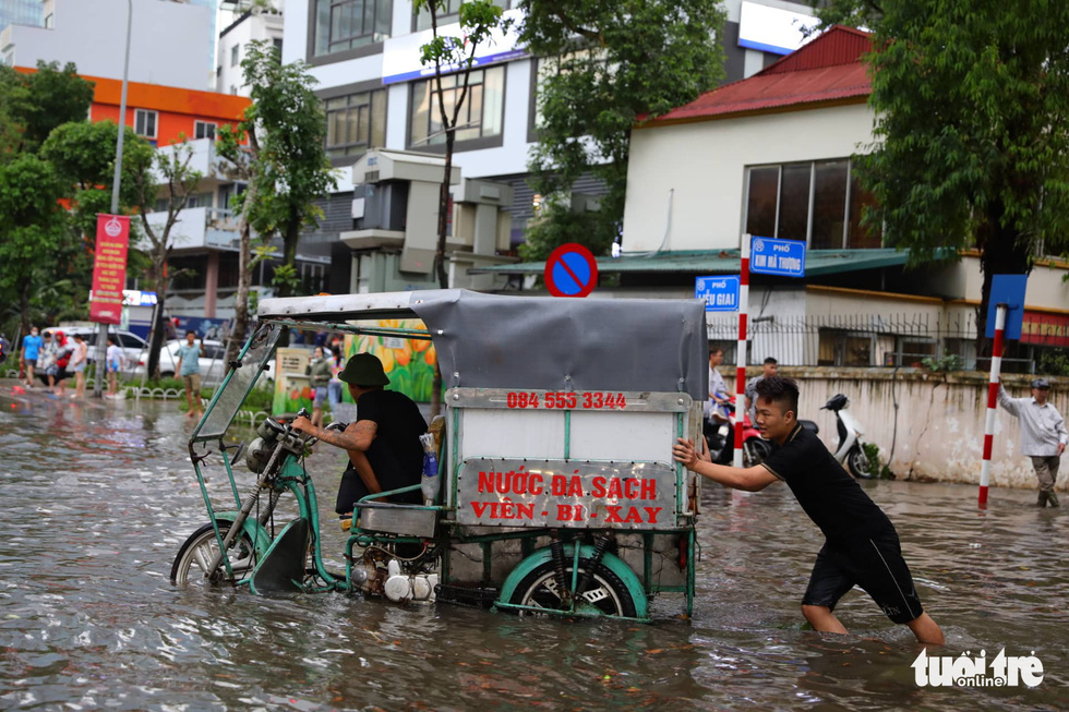 Đường phố Hà Nội hỗn loạn, ùn tắc dài sau cơn mưa 160mm hiếm gặp - Ảnh 2.