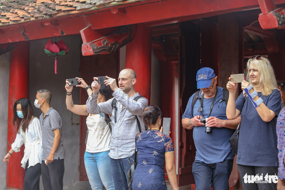 Du khách nước ngoài thích thú chụp ảnh tốt nghiệp cùng học sinh Việt Nam - Ảnh 3.