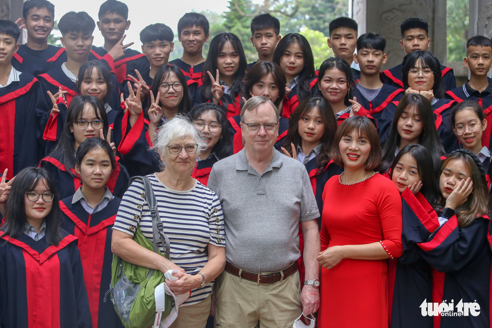 Du khách nước ngoài thích thú chụp ảnh tốt nghiệp cùng học sinh Việt Nam - Ảnh 1.