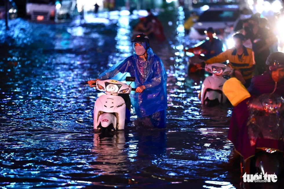 Hà Nội mưa chưa đầy 1 giờ, nhiều tuyến phố thành sông, nước tràn vào nhà dân - Ảnh 4.