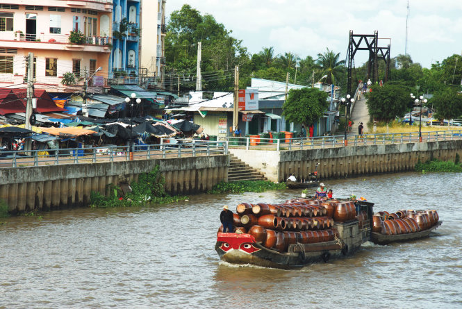 Trên những chuyến đò, theo những dòng kênh, những chiếc lu đến với người dân - Ảnh: H.T.V.