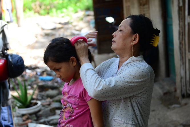 Chị Hồng Cẩm cột tóc cho con gái lúc rảnh rỗi