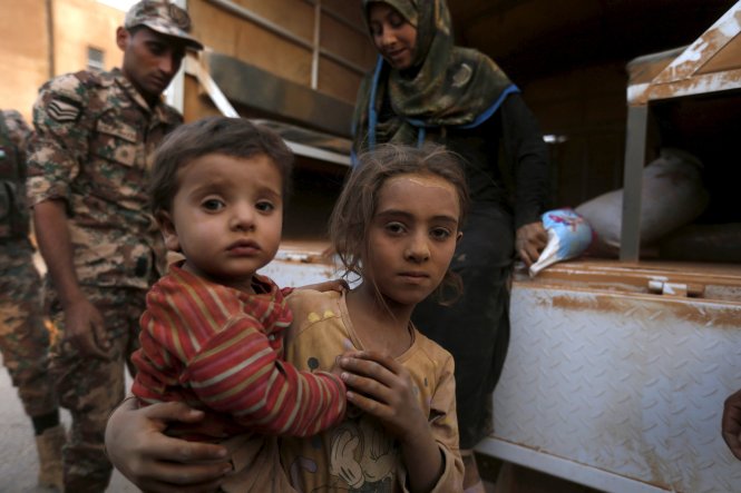 Lính Jordan giúp trẻ tị nạn Syria tại vùng biên giới Trabeel, sau khi các em cùng gia đình vượt qua lãnh thổ Jordan-Reuters