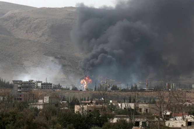 Khói bốc lên từ căn cứ quân sự của lực lượng Chính phủ Syria sau cuộc đụng độ với lực lượng vũ trang đối lập ngày 13-9 tại vùng núi gần thành phố Duma, cách Damascus 10km về phía đông bắc -Reuters