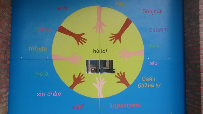 Một trường học tại Bỉ tự hào về sự đa dạng văn hóa bằng cách in lời chào bằng nhiều thứ tiếng (trong đó có cả tiếng Việt) lên cổng trường-KBH