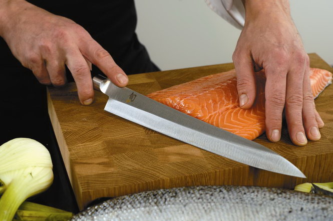 Dùng dao KAI của Nhật để cắt cá hồi thành từng miếng mỏng