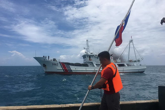 Một nhà hoạt động Philippines tìm cách cắm cờ trên tàu ở gần bãi cạn Scarborough, ngoài xa là một tàu tuần duyên Trung Quốc -straitstimes.com