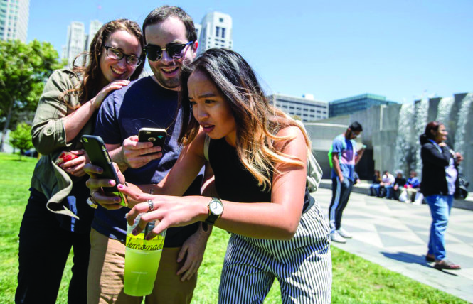 (From left) Michaela Wood, Michael French and Amanda Gomez search for Pokemon through the new Pokemon GO app at Yerba Buena Gardens in San Francisco, Calif. Tuesday, July 12, 2016. (Jessica Christian/S.F. Examiner)