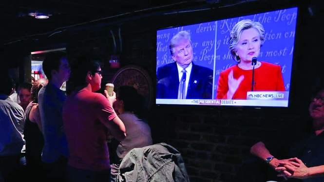 Người dân Mỹ theo dõi cuộc tranh luận của Hillary Clinton và Donald Trump qua truyền hình. nbcnewyork.com