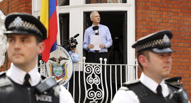 Ông Assange phát biểu với những người ủng hộ từ Đại sứ quán Ecuador ở London tháng 8-2016, với hàng rào cảnh sát phía trước -AFP