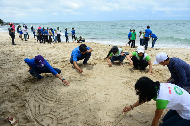 Các bạn trẻ vẽ tranh trên cát để cổ động cho Phú Quốc xanh