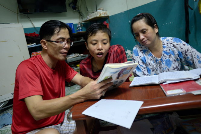 Anh chị Bùi Tiến Phúc và chị Lý Thị Thêm cùng dạy con học - Ảnh: Quang Định