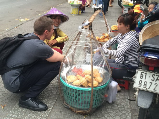 Andrew Davey, còn gọi là Ăn Đu Đủ, ngồi xổm ăn món ăn đường phố Việt Nam