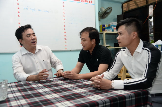 Cán bộ Phòng kinh tế Q.Tân Bình (bìa trái) giải thích các thủ tục hành chính cho anh Hoàng Thanh Hải (giữa) - quản lý Công ty TNHH Giang Ghẹ -Tự Trung