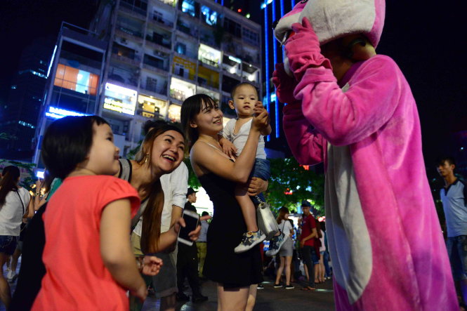 Mascot thỏ hồng chơi đùa với trẻ em trên phố-Hữu Khoa