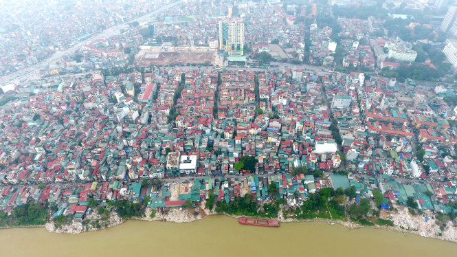 Sông Hồng chảy qua khu vực nội thành Hà Nội, xung quanh là hàng ngàn ngôi nhà nằm san sát nhau -Khánh Linh