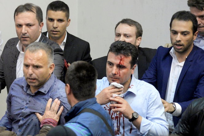 Ông Zoran Zaev, lãnh đạo phe đối lập, được hộ tống rời tòa nhà quốc hội sau vụ tấn công ngày 27-4 -gulfnews.com