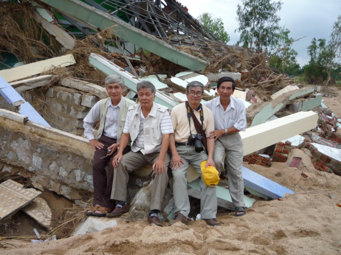 Nhà thơ Nguyễn Duy (thứ ba từ trái sang) trong cảnh đổ nát của Trường tiểu học Xuân Sơn Bắc khi cơn lũ dữ tháng 11-2009 tàn phá nhiều địa phương của tỉnh Phú Yên