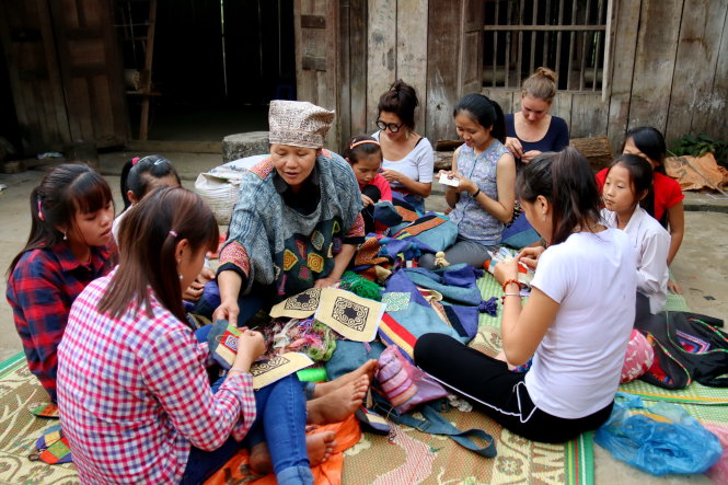 Nghệ nhân Vàng Thị Mai (đội mũ) cùng làm việc với các vị khách quốc tế và trẻ em Mông ở Lùng Tám -NGỌC HIỂN