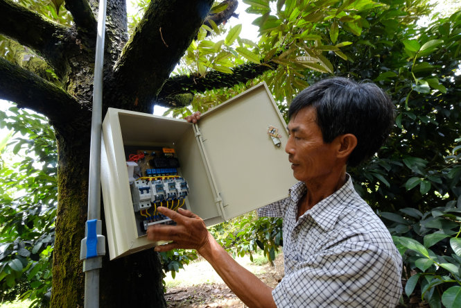 Ông Nguyễn Văn Tám đầu tư hệ thống tưới có thể điều khiển từ xa bằng điện thoại                     -Ảnh: MAI VINH