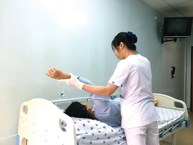 Bệnh nhân được hỗ trợ tập bài tập vai (ảnh chụp tại bv Đại học Y dược TP.HCM). Ảnh: Huỳnh Thị Minh Thùy