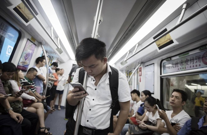 Cảnh tượng thường thấy trên một chuyến tàu điện ngầm ở thành phố Thâm Quyến, Trung Quốc. Điện thoại thông minh đã khiến trí khôn xã hội của chúng ta giảm sút? -Ảnh: wsj.com