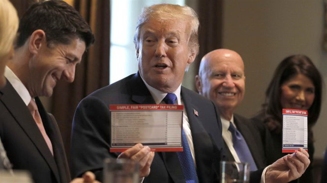 Ông Trump và tờ khai thuế mới mà ông khoe là giản tiện chỉ còn bằng một tấm bưu thiếp sau khi đạo luật mới được thông qua. -Ảnh: NBC News