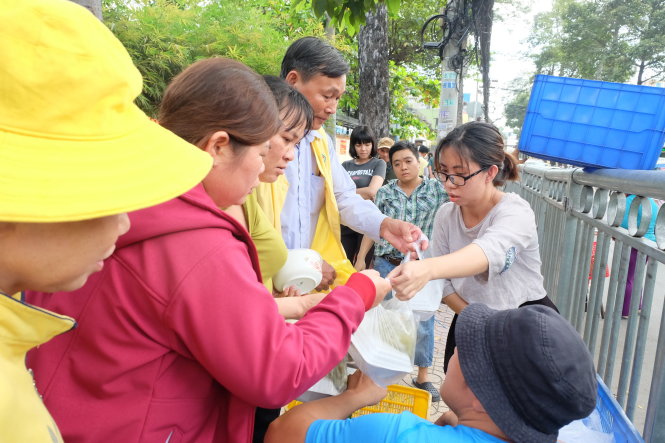 Thùy Trang (phải) đưa cơm cho các cô chú bệnh nhân tại Bệnh viện Chợ Rẫy (TP.HCM).-Ảnh: Vũ Thủy